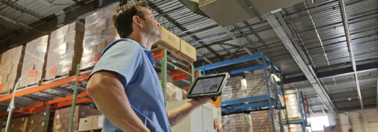 Lagerarbeiter bedient Warehouse Management System auf einem Tablet