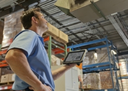 Lagerarbeiter bedient Warehouse Management System auf einem Tablet