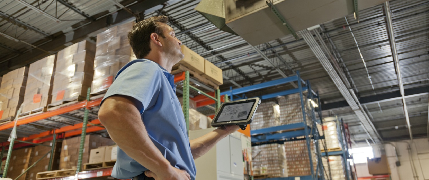 Lagerarbeiter bedient Warehouse Management System auf einem Tablet
